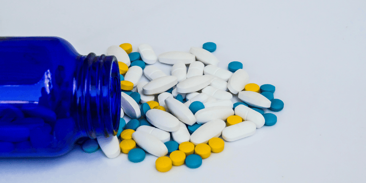 Loratadine (Claritin) and other antihistamine pills spread across a white table.