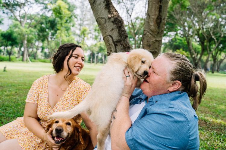 A sitter happily playing with a client’s puppy