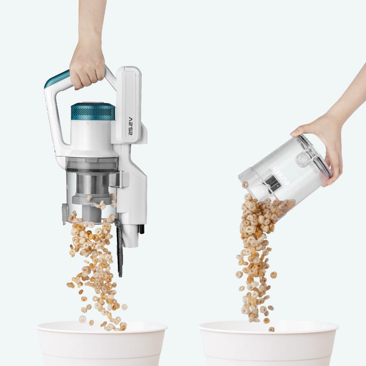 A hand holding a vacuum cleaner pouring cereal Description automatically generated