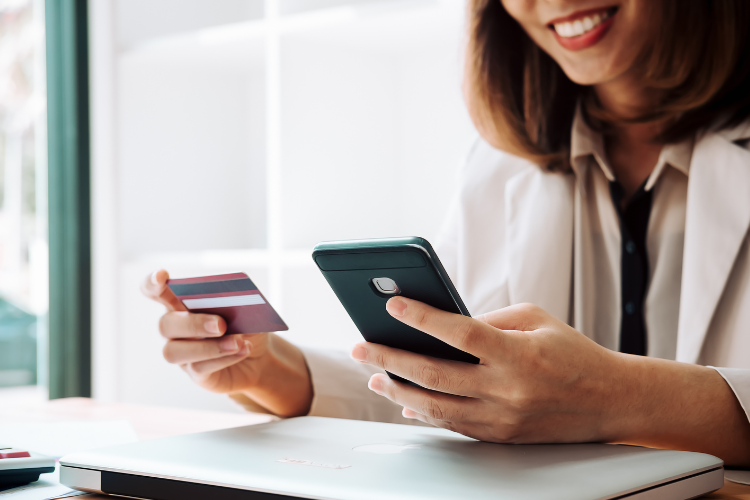 a woman paying for a pet-sitting service using her credit card and phone