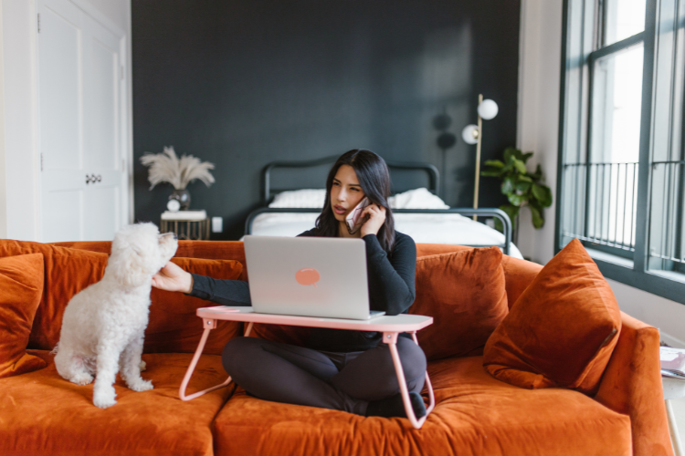 a woman interviewing a pet-sitter on the phone while she pets her dog