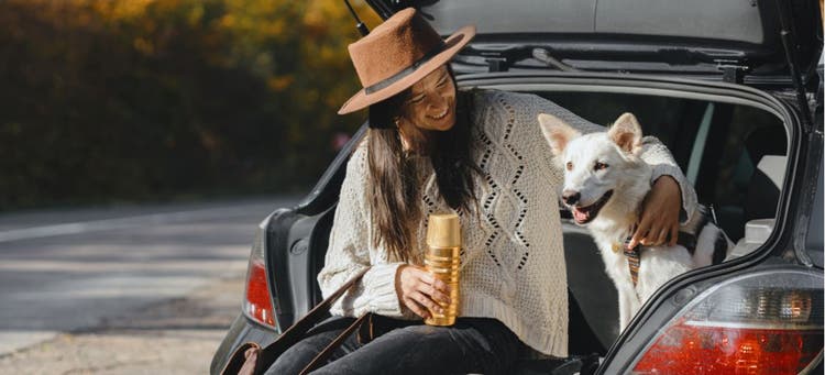A woman and her pet on a road trip.